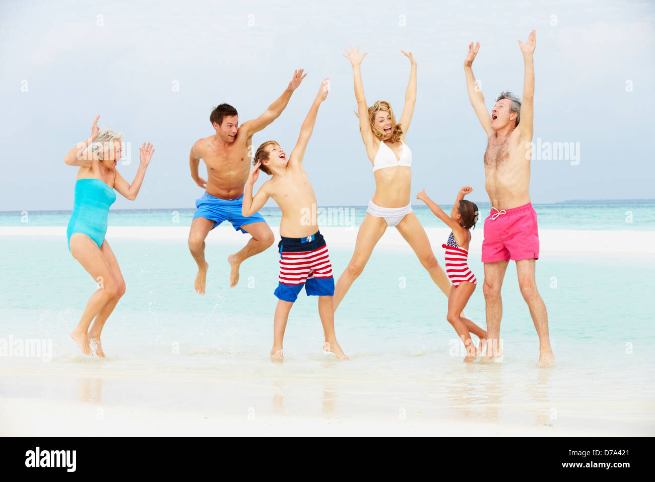 Multi Generation Family Having Fun In Sea On Beach Holiday Stock Photo