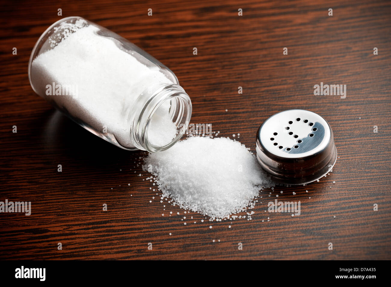 salt sprinkled on wooden table Stock Photo