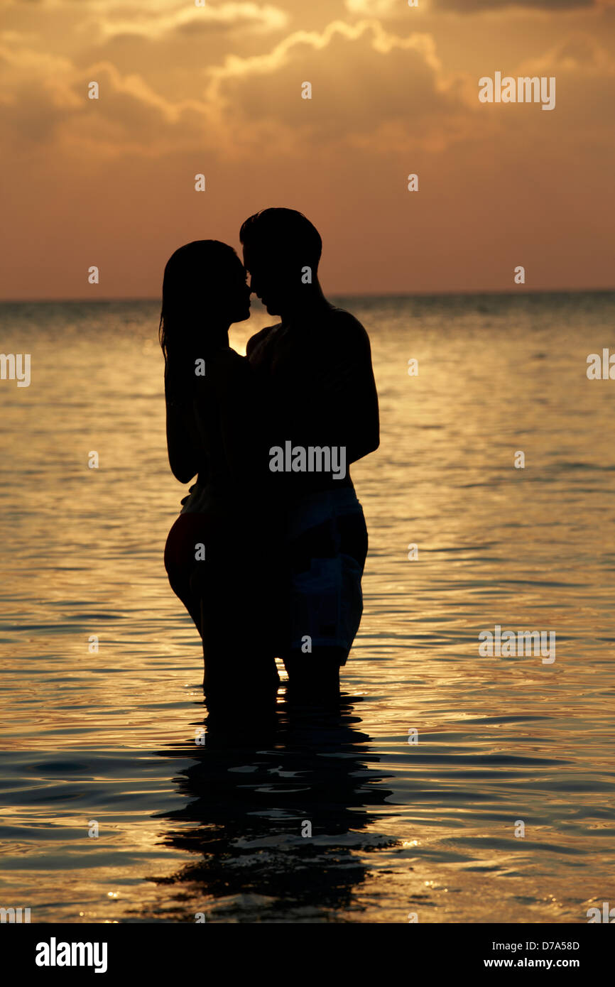 Silhouette Of Romantic Couple Standing In Sea Stock Photo - Alamy
