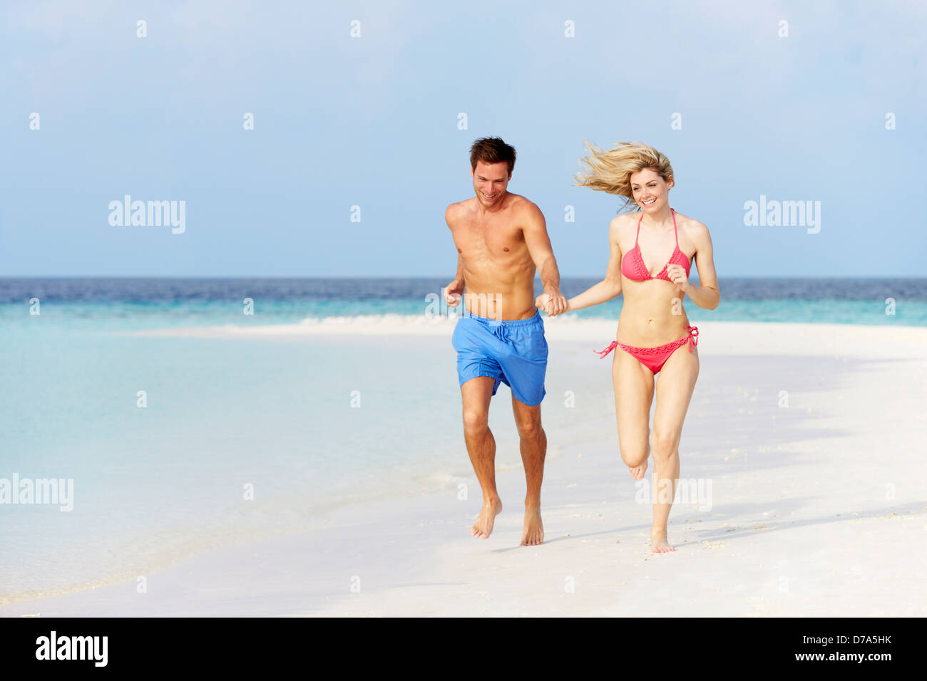 Romantic Couple Running On Beautiful Tropical Beach Stock Photo