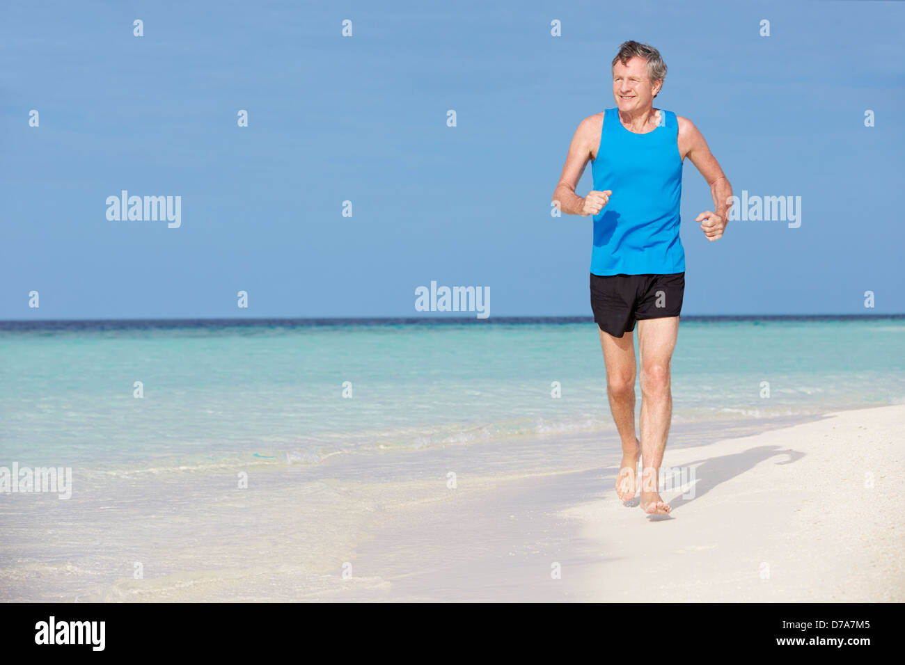 Senior Man Running On Beautiful Beach Stock Photo