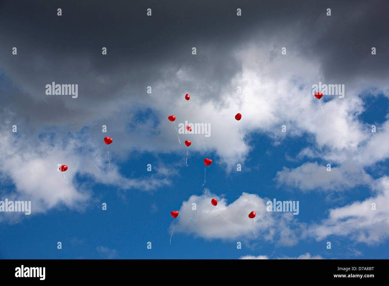 Red Heart Balloons airborne with cloudy blue sky Stock Photo - Alamy