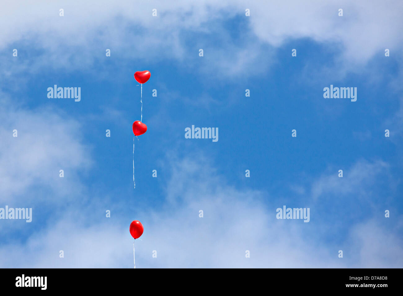 Red Heart Balloons airborne with cloudy blue sky Stock Photo - Alamy