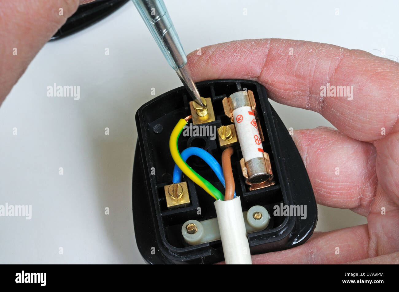 Man wiring English 3 pin 13 amp plug - inserting earth wire, England, UK,  Western Europe Stock Photo - Alamy