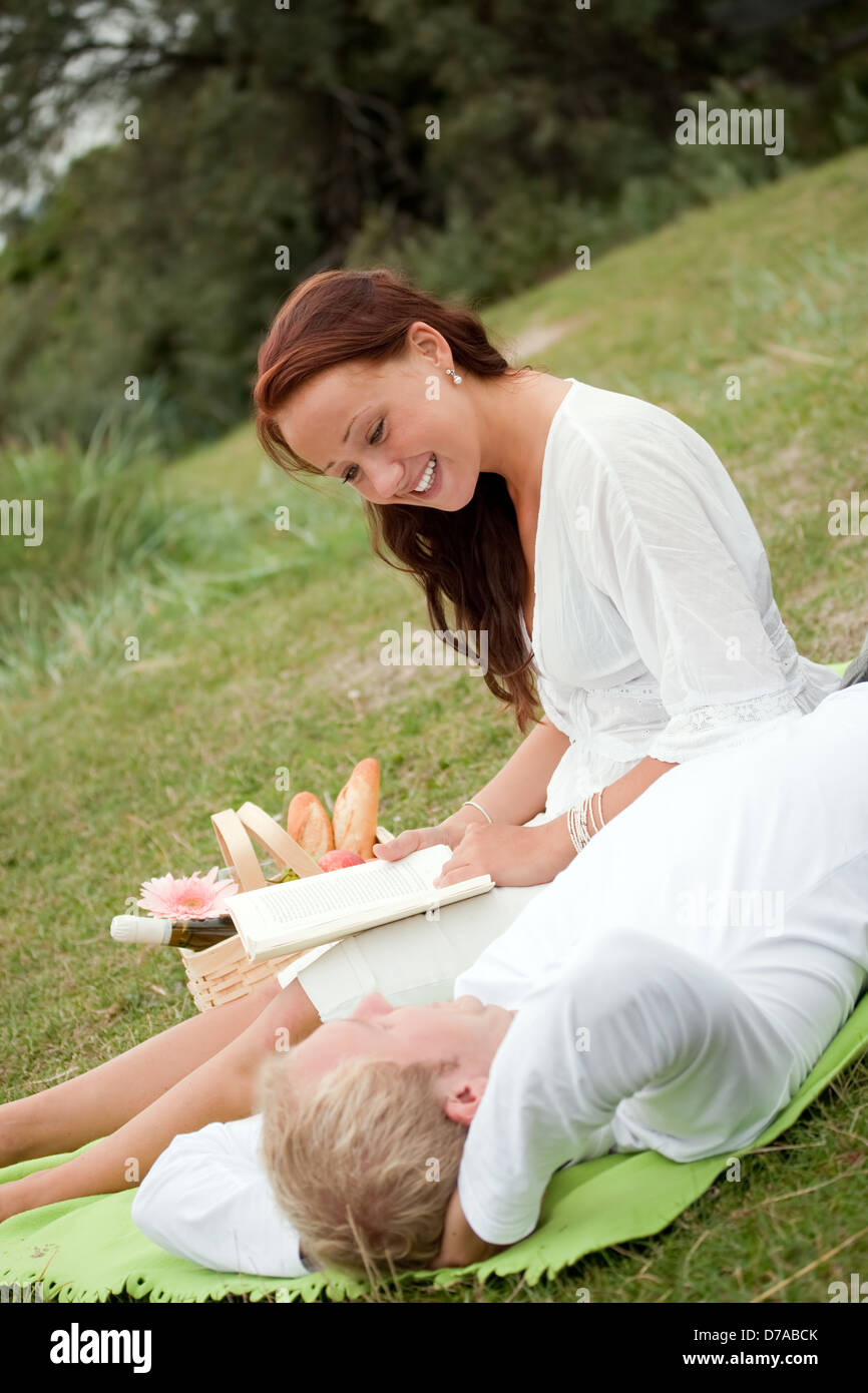 Lifestyle, happy couple resting at a picnic in the park with a dog ...