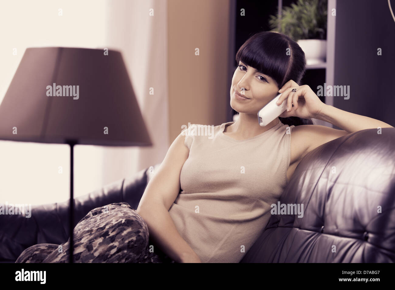portrait of a young calling woman in the living room Stock Photo