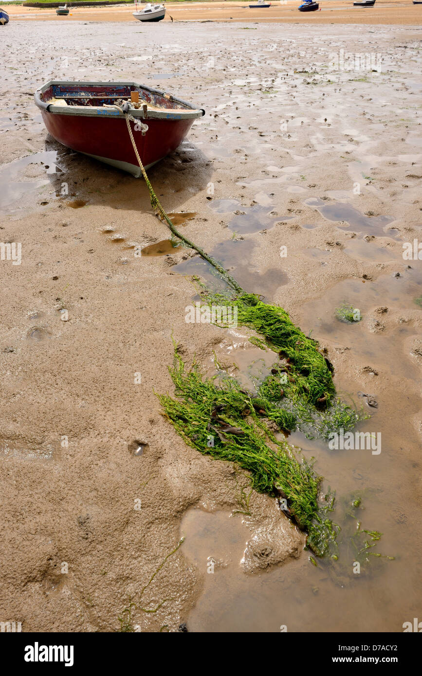 Beached rowing boat on sand, Tide out. Stock Photo