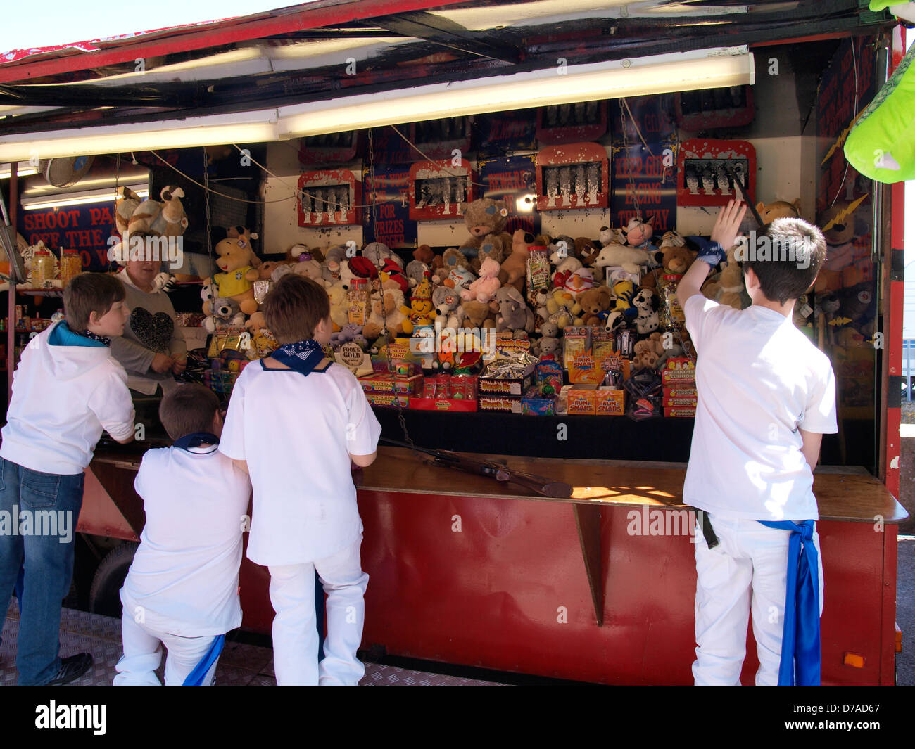 Young boys at a shooting gallery, fairground stall, UK 2013 Stock Photo