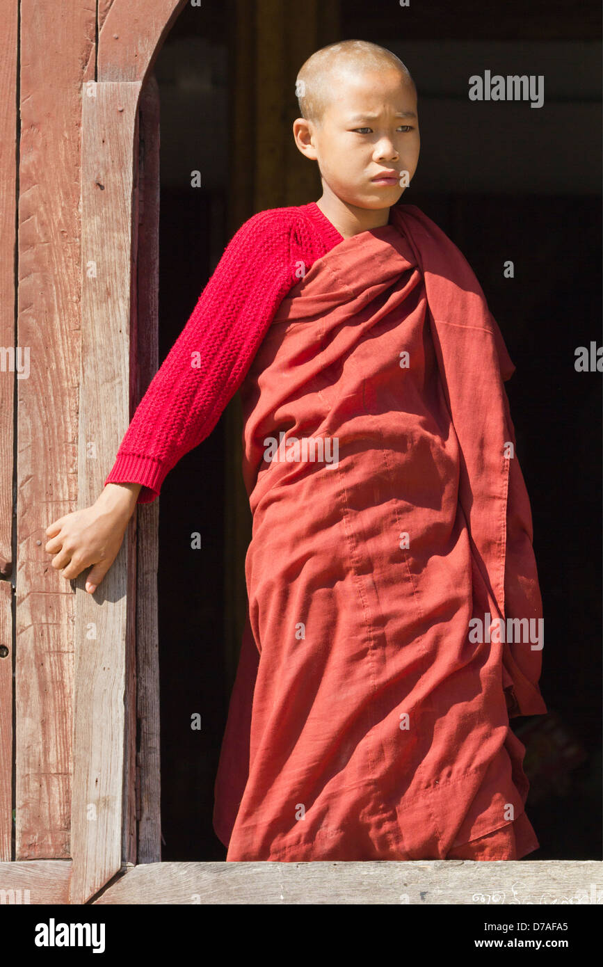 A young monk by the window in Shwe Yaunghwe Kyaung Monastery near Lake Inle, Myanmar 5 Stock Photo