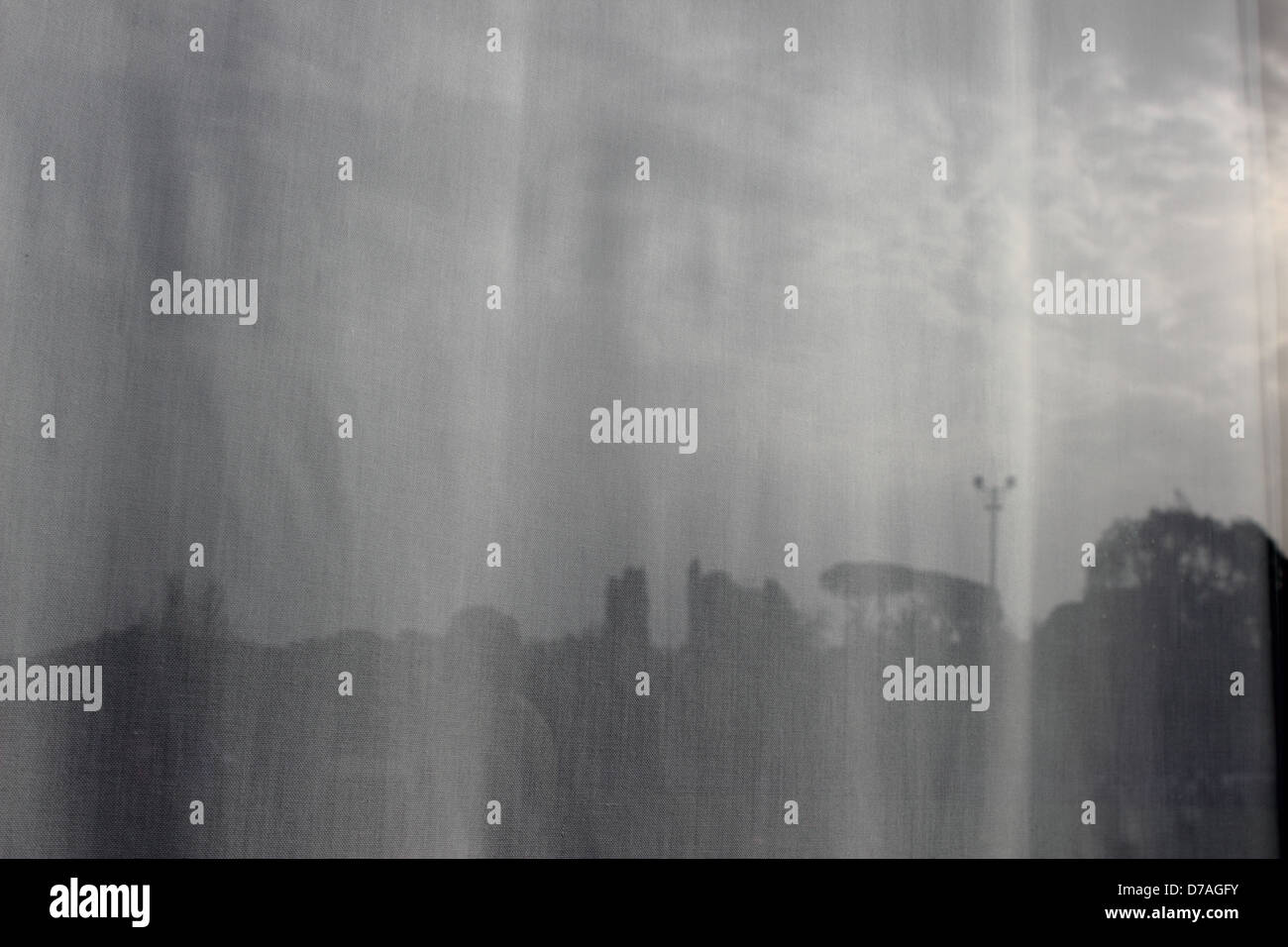 landscape reflected in a window's glass and curtain Stock Photo