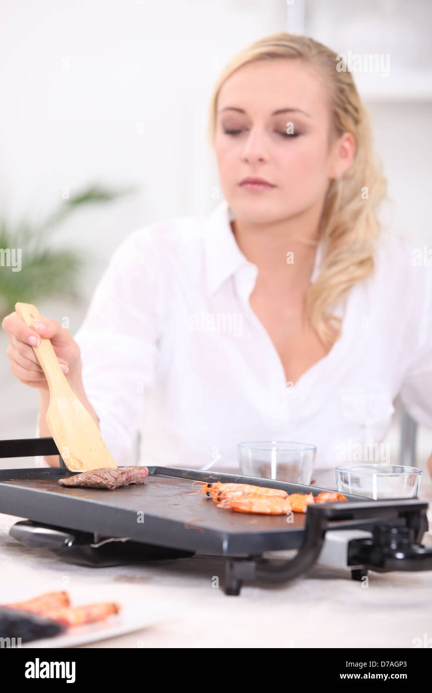 Woman using griddle Stock Photo Alamy
