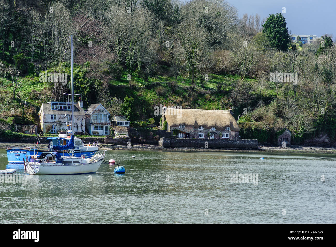 River Dart Devon with a thatched cottage on the river bank with a boat