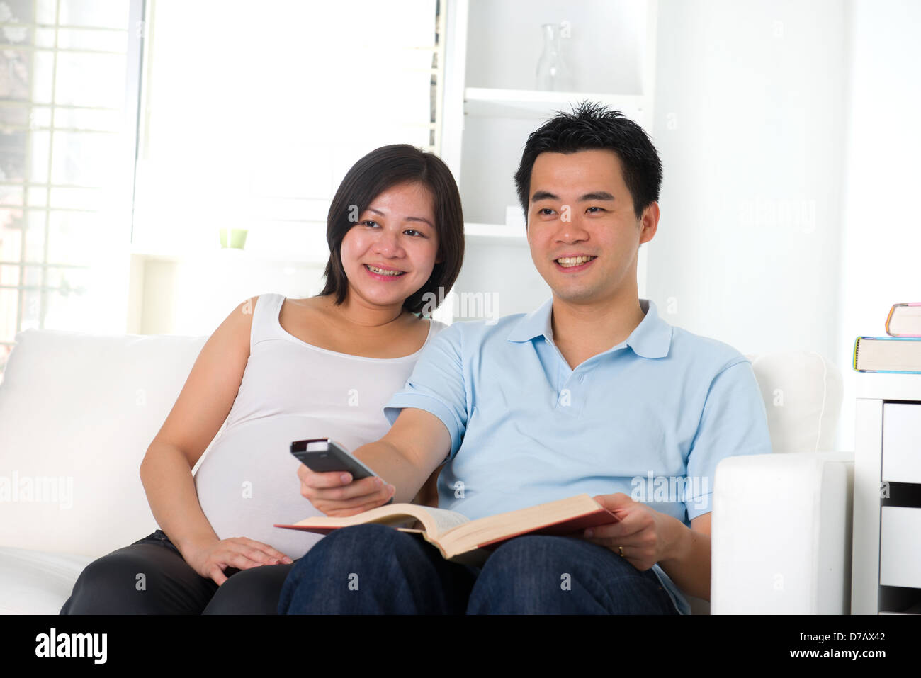 pregnancy husband and wife lifestyle photo reading book and watching