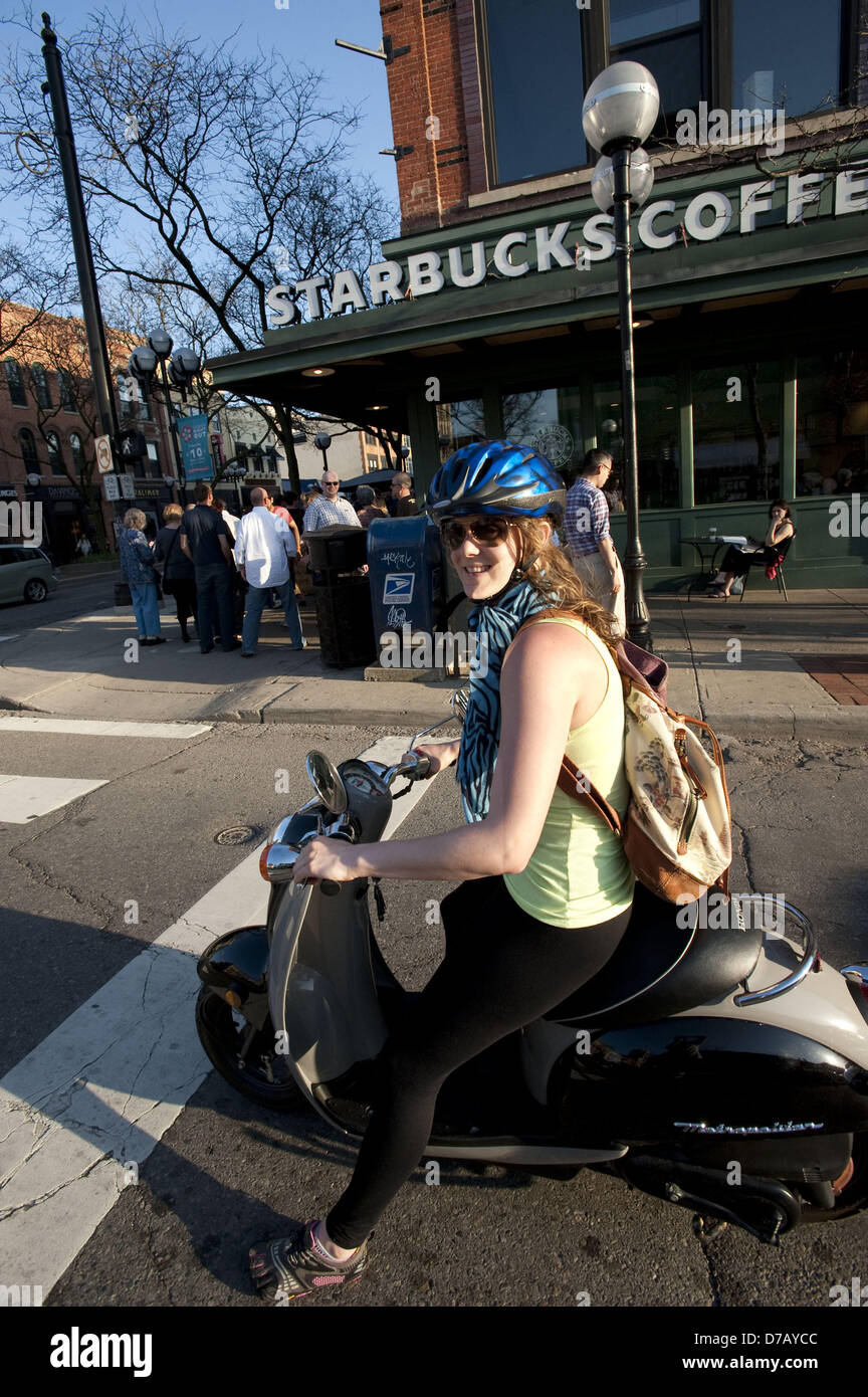 May 1, 2013 Ann Arbor, Michigan, U.S A lady on a scooter waits at a traffic light on a warm