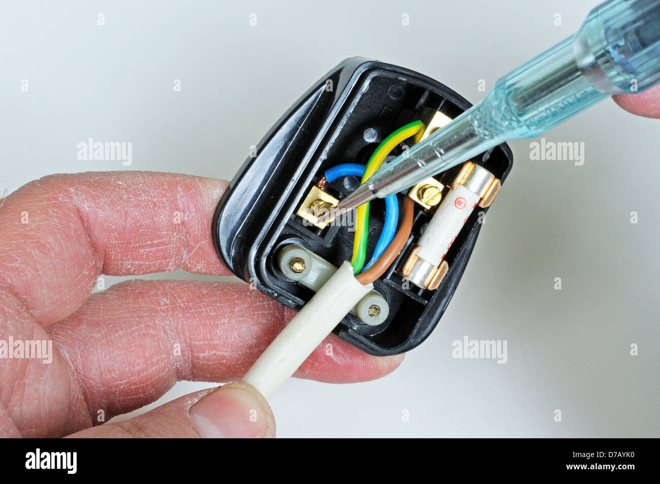 Man wiring English 3 pin 13 amp plug - inserting neutral wire, England, UK, Western Europe. Stock Photo