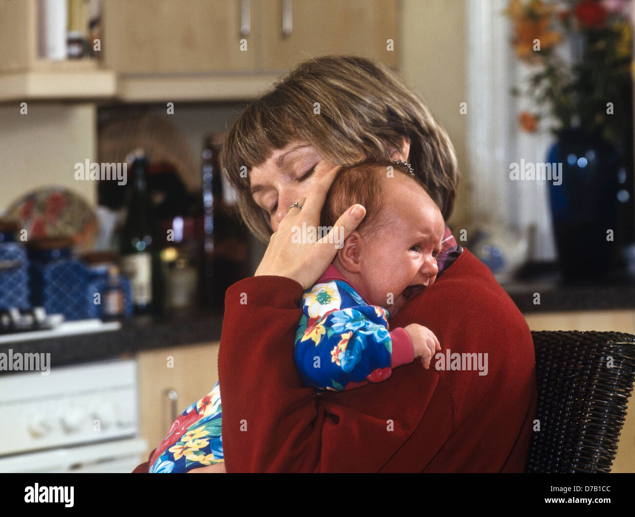 Affectionate mom cuddling newborn hires stock photography and images