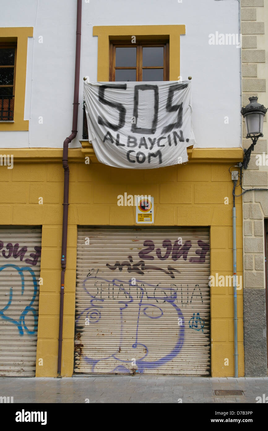 SOS Albaycin banner draped on closed shops in the Albaycin area of Granada Stock Photo