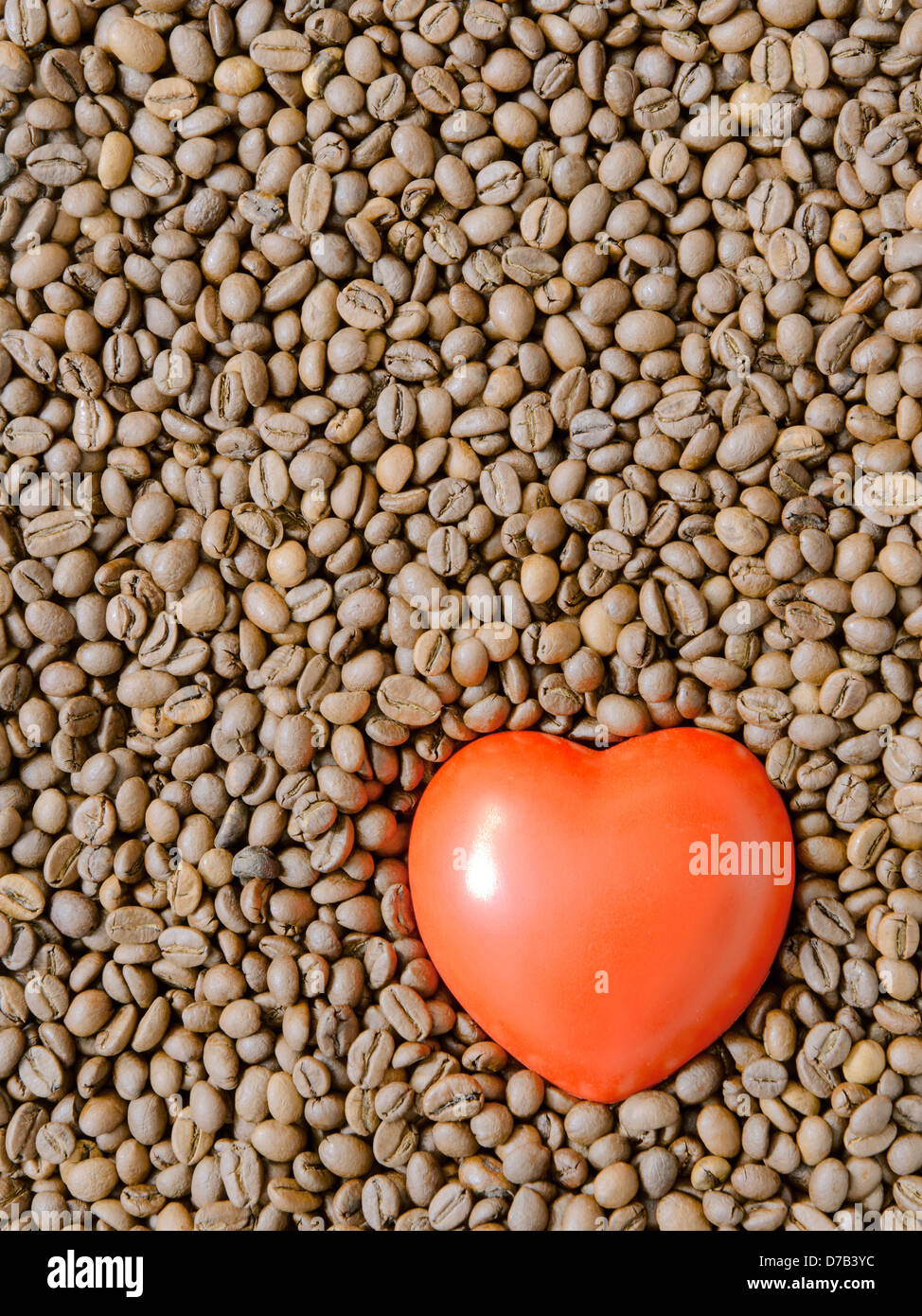 detailed roasted coffee beans background with red heart symbol on it Stock Photo