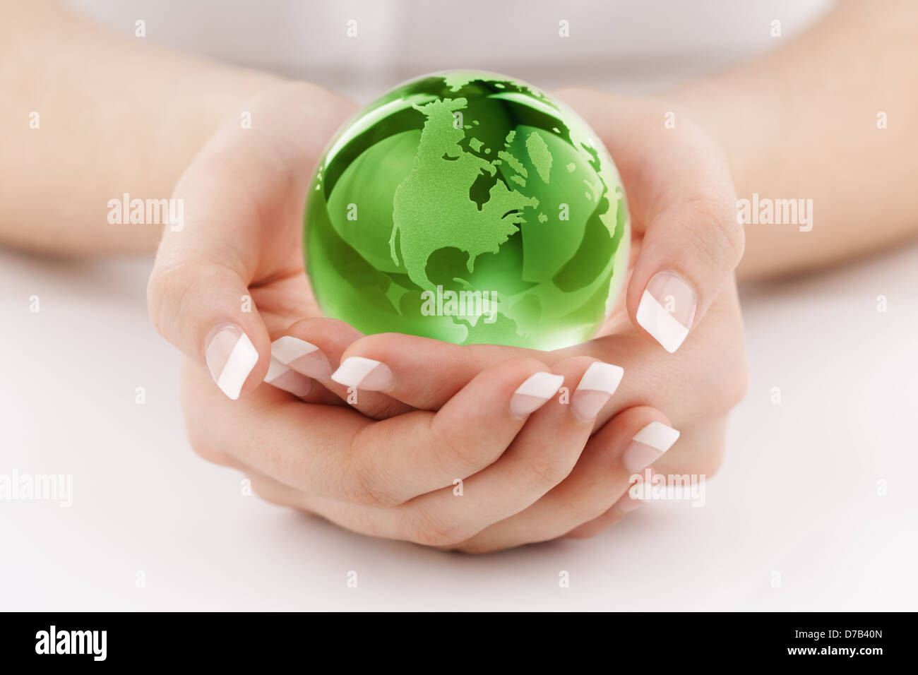 Green globe in hands Stock Photo
