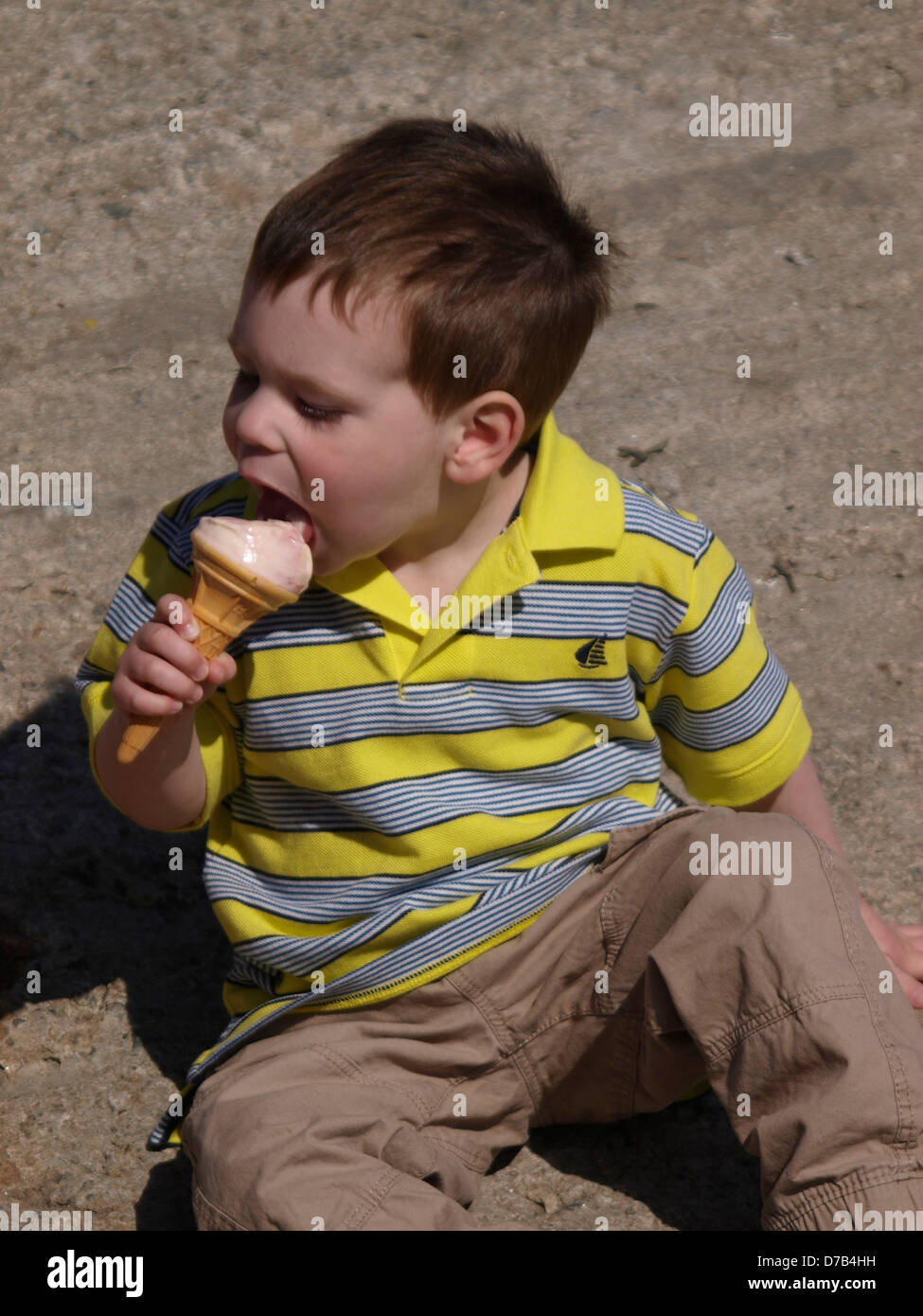 Young boy eating an icecream, UK 2013 Stock Photo