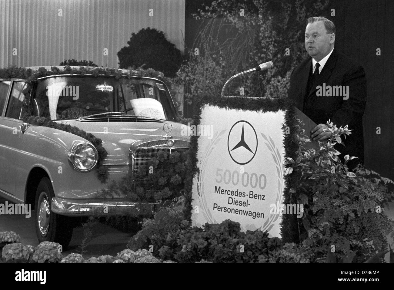 Daimler-Benz general director Walter Hitzinger is giving a speech on the 500,000th Mercedes-Benz Diesel car, on 8 April 1965, in Sindelfingen. On the left, the anniversary wagon from the assembly plant in Sindelfingen. Stock Photo