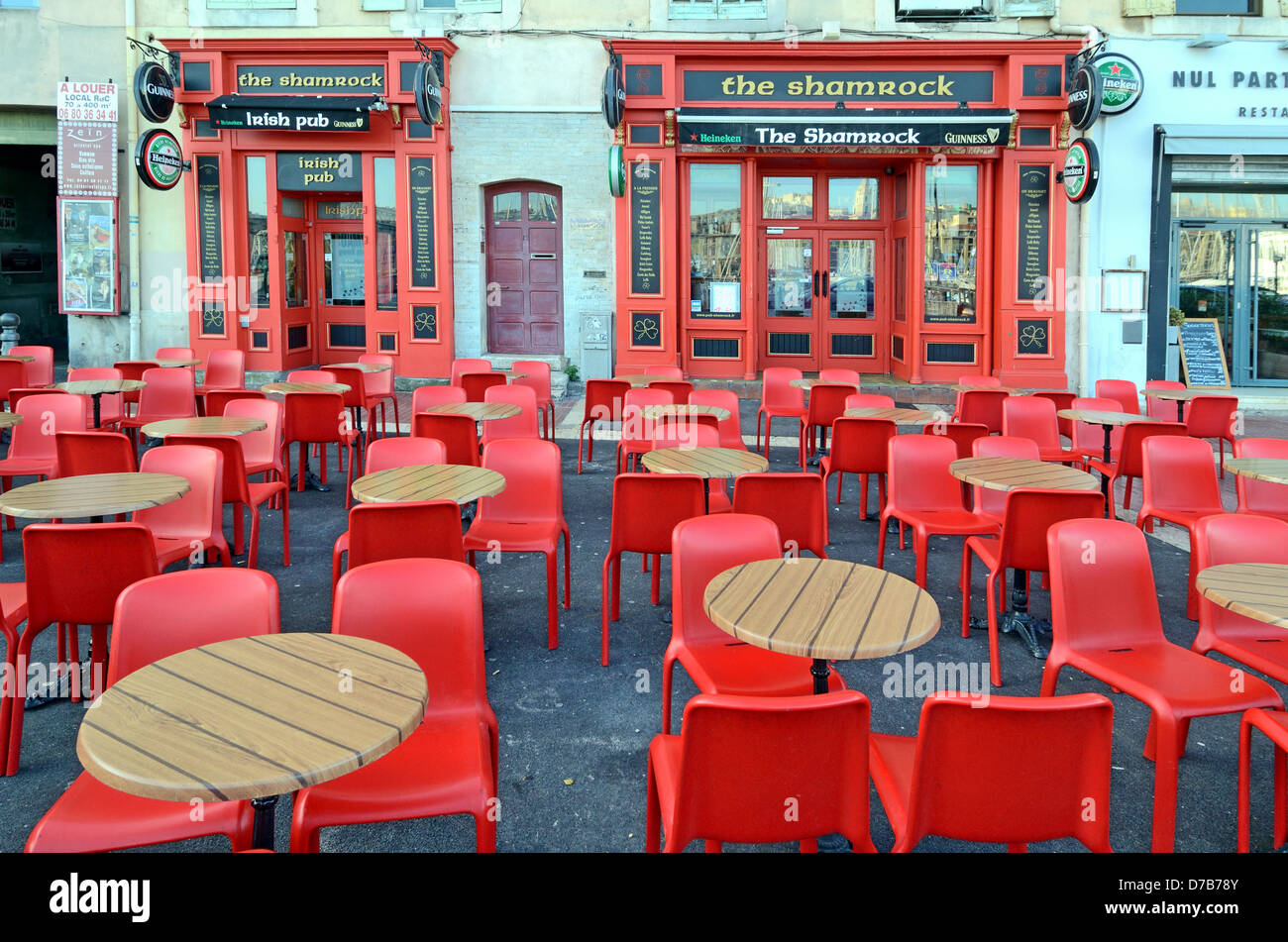 Closed Irish Pub Bar or Empty Pavement Café with Deserted Tables and Plastic Red Chairs Old Port or Vieux Port Marseille Provence France Stock Photo