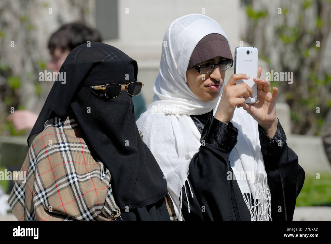 London, England, UK. Muslim women with iPhone and sunglasses. Hadjib / hijab Stock Photo