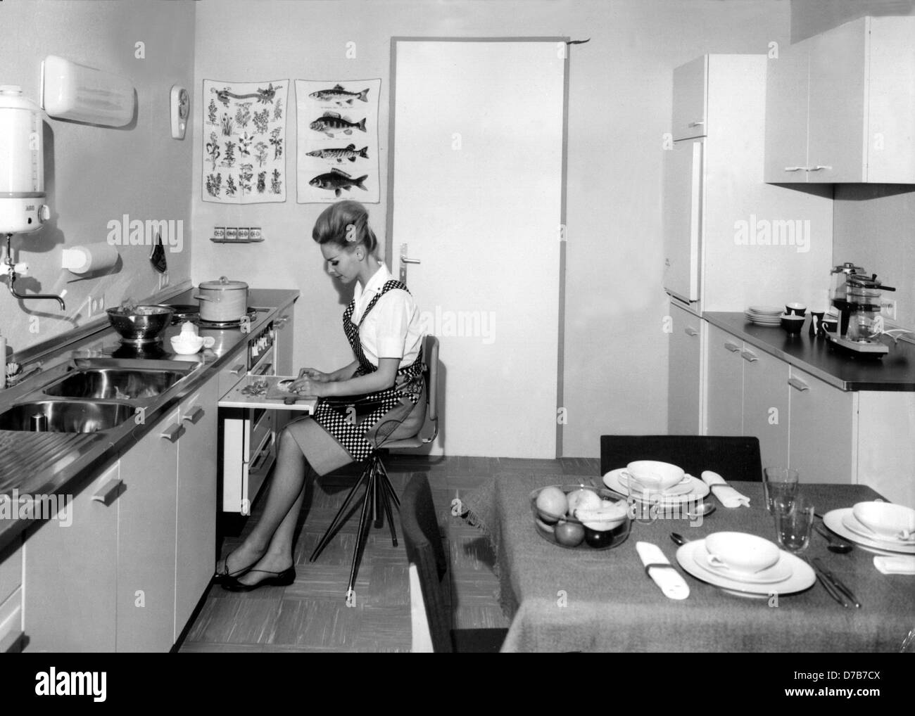 A housewife can prepare her vegetables at an extendible worktop while sitting. This ergonomic kitchen was ultra modern in the 1960s. Stock Photo