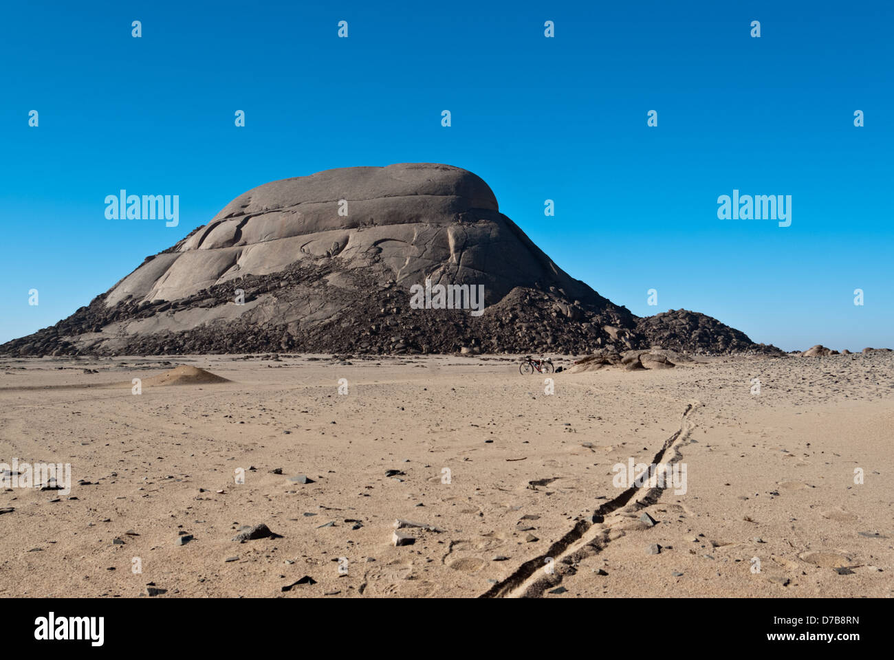 My bicycle under Jabel Silai'i Mountain near Sheikh Shazli (Humaithara) village with bike track on sand, Eastern Arabian Desert, Upper Egypt Stock Photo