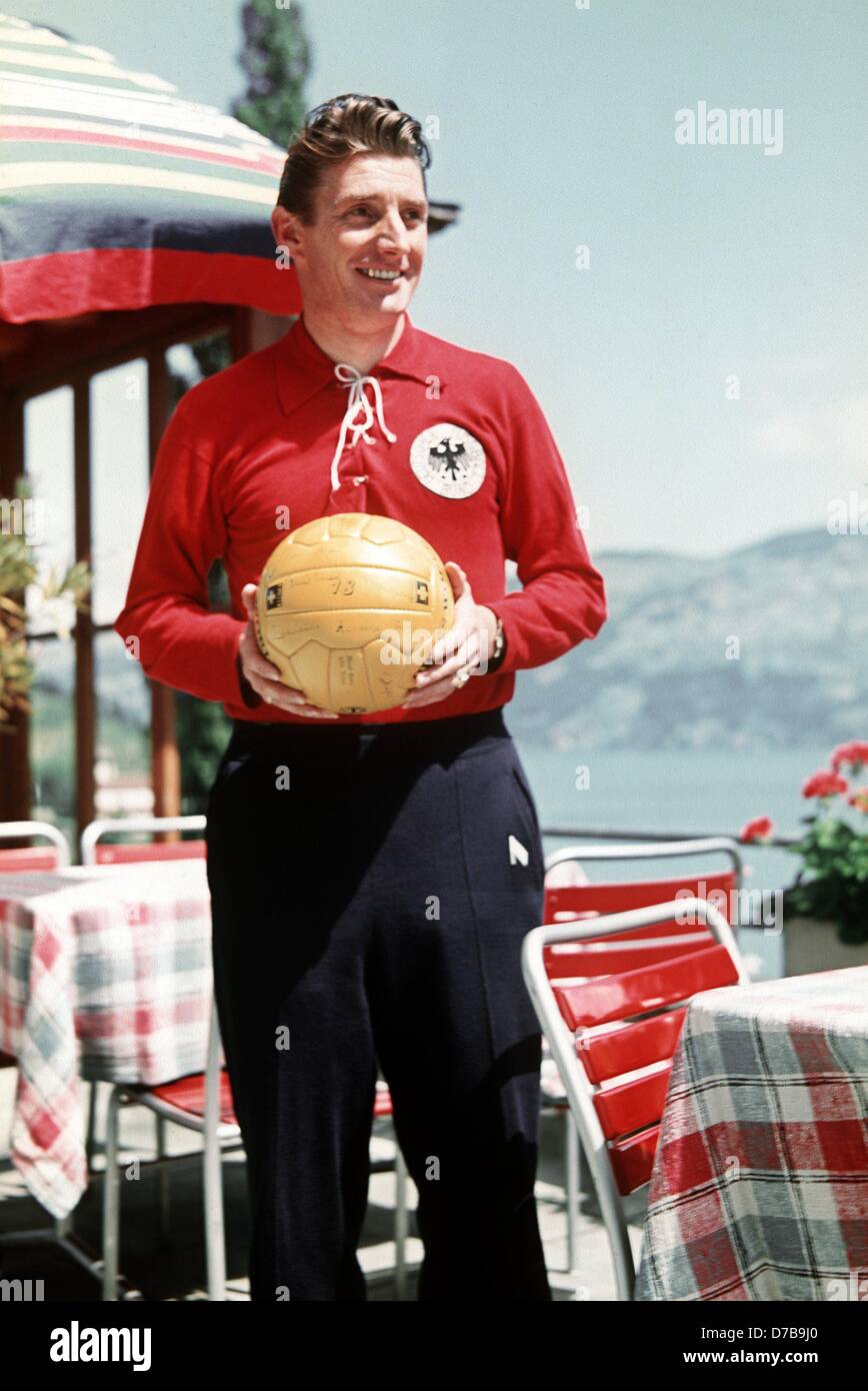 German soccer player Fritz Walter wears a track suit and holds a soccer ball in his hands in 1954. The famous sports idol played for the 1st FC Kaiserslautern soccer club from 1928 until 1959, winning the German league title in 1951 and 1953. He celebrated his biggest success as captain of the German national team winning the World Cup in Berne, Switzerland, 1954. Walter was born on 31 October 1920 in Kaiserslautern and has been honorary captain of the German national team since 1958. Stock Photo