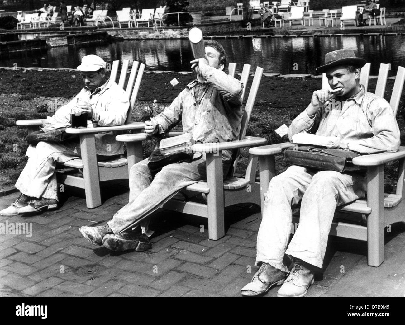 Three painters have their breakfast break in the sun in the park of Planten and Blomen in Hamburg, photographed in 1956. Stock Photo