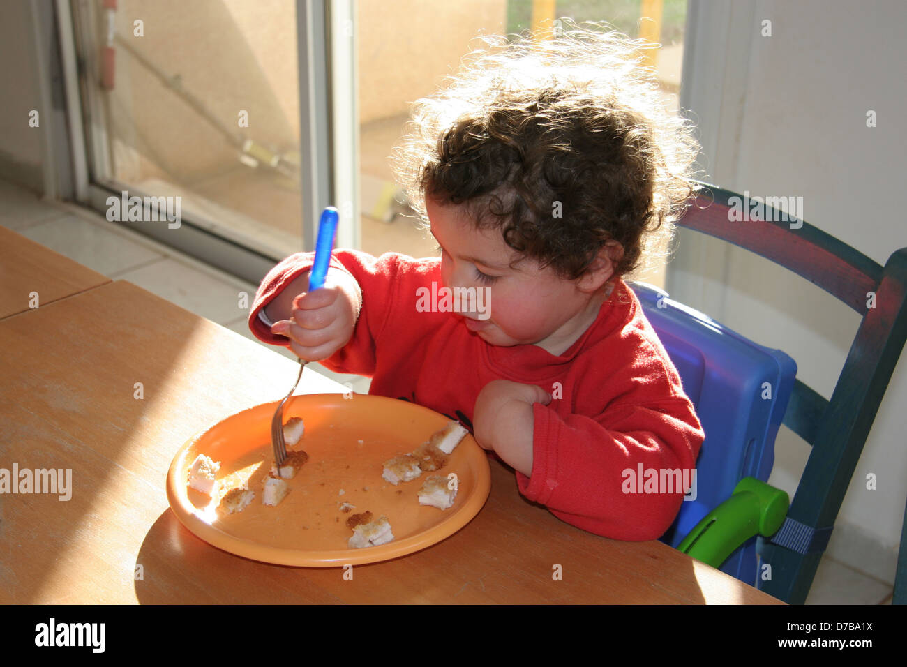 young child eating by herself Stock Photo