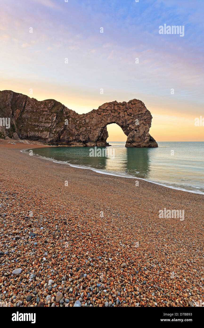 Durdle Door in Dorset. Taken at sunrise as the tide is going out on the shingle beach. Stock Photo