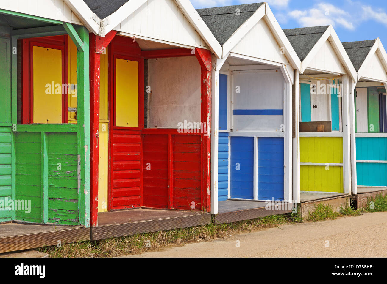 A row of old weathered colourful wooden beach huts. Stock Photo