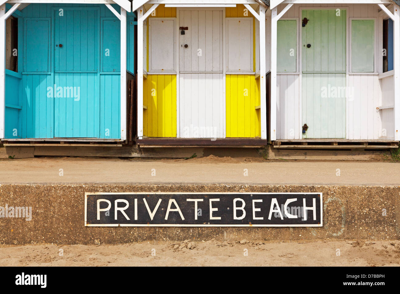 Old wooden beach huts on a Private beach with sign Stock Photo