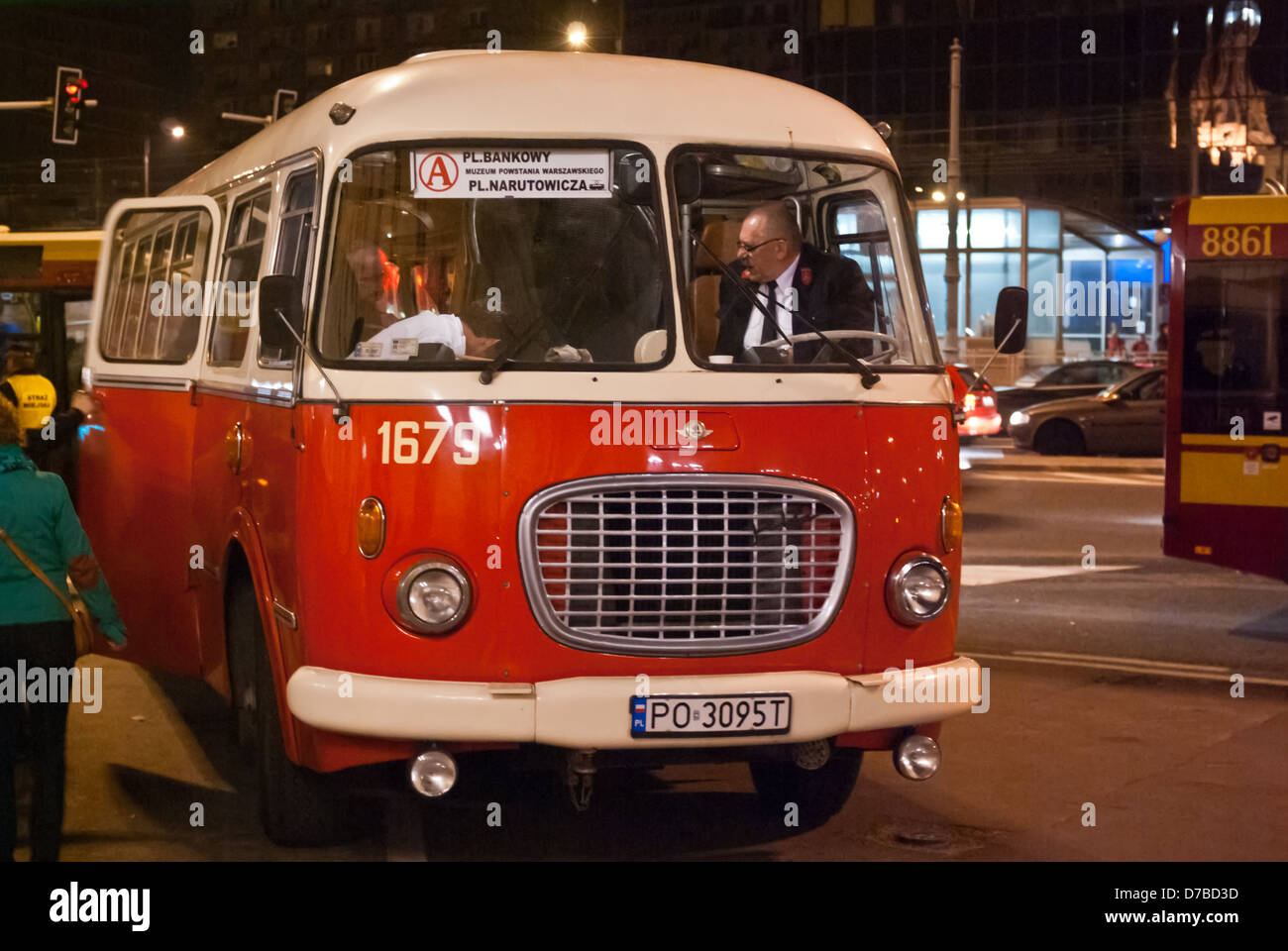 Vintage red city bus (Polish Jelcz 043) so-called ogórek (cucumber) near the City Hall taken in the night, Plac Bankowy, Warsaw Stock Photo