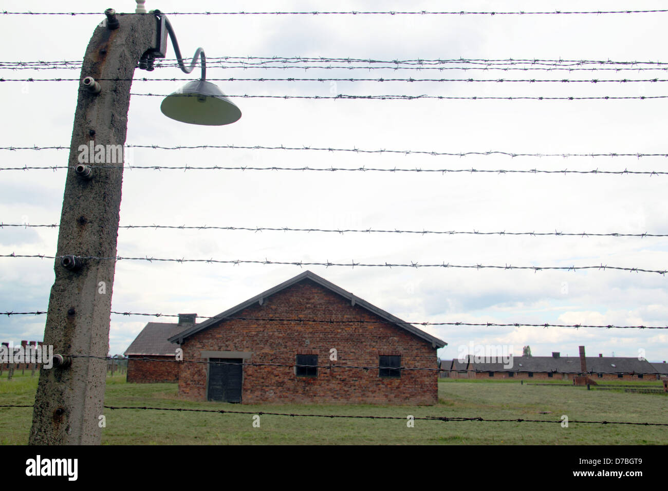 Barbed wired fence surrounding the prisoners' barracks at Auschwitz-Birkenau concentration camp in Poland Stock Photo
