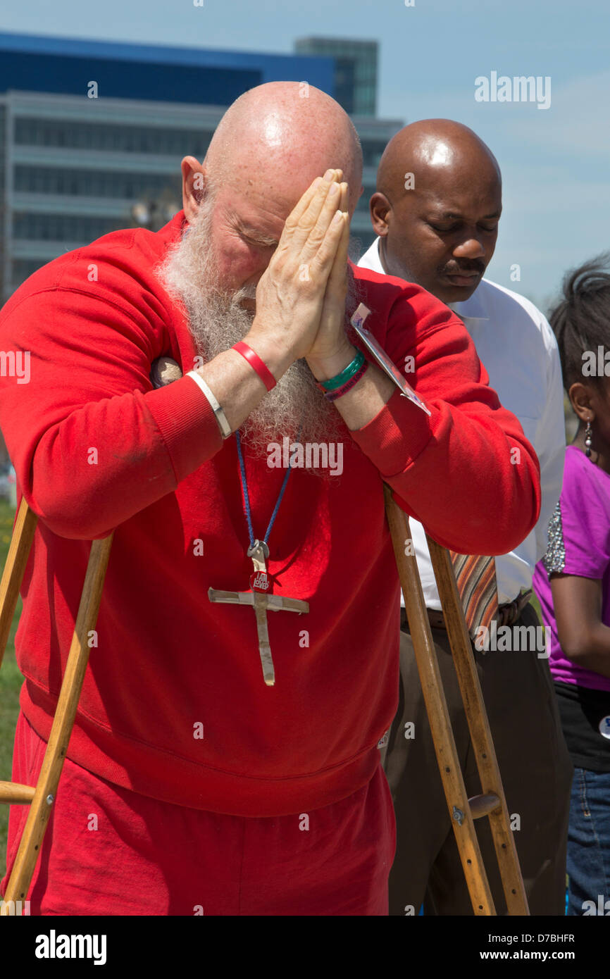 Warren, Michigan, USA. Leaning on his crutches, Hiram Squires prays during the annual National Day of Prayer observance at city hall. Credit:  Jim West / Alamy Live News Stock Photo