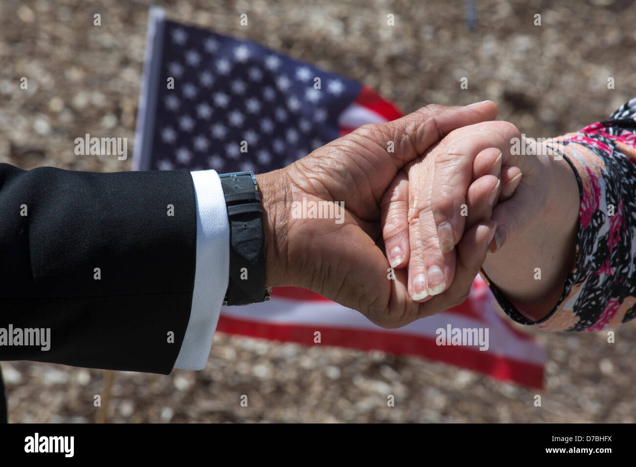 Warren, Michigan, USA. An African-American man and a Caucasian woman hold hands while praying during the annual National Day of Prayer observance at city hall. Credit:  Jim West / Alamy Live News Stock Photo