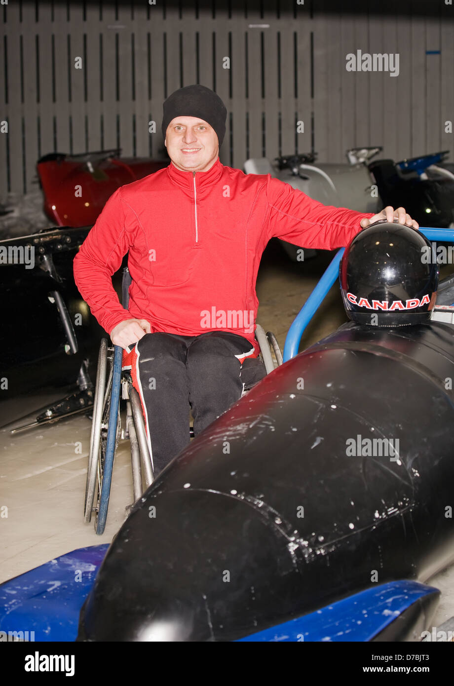 Wheelchair athlete next to bobsled;Calgary alberta canada Stock Photo