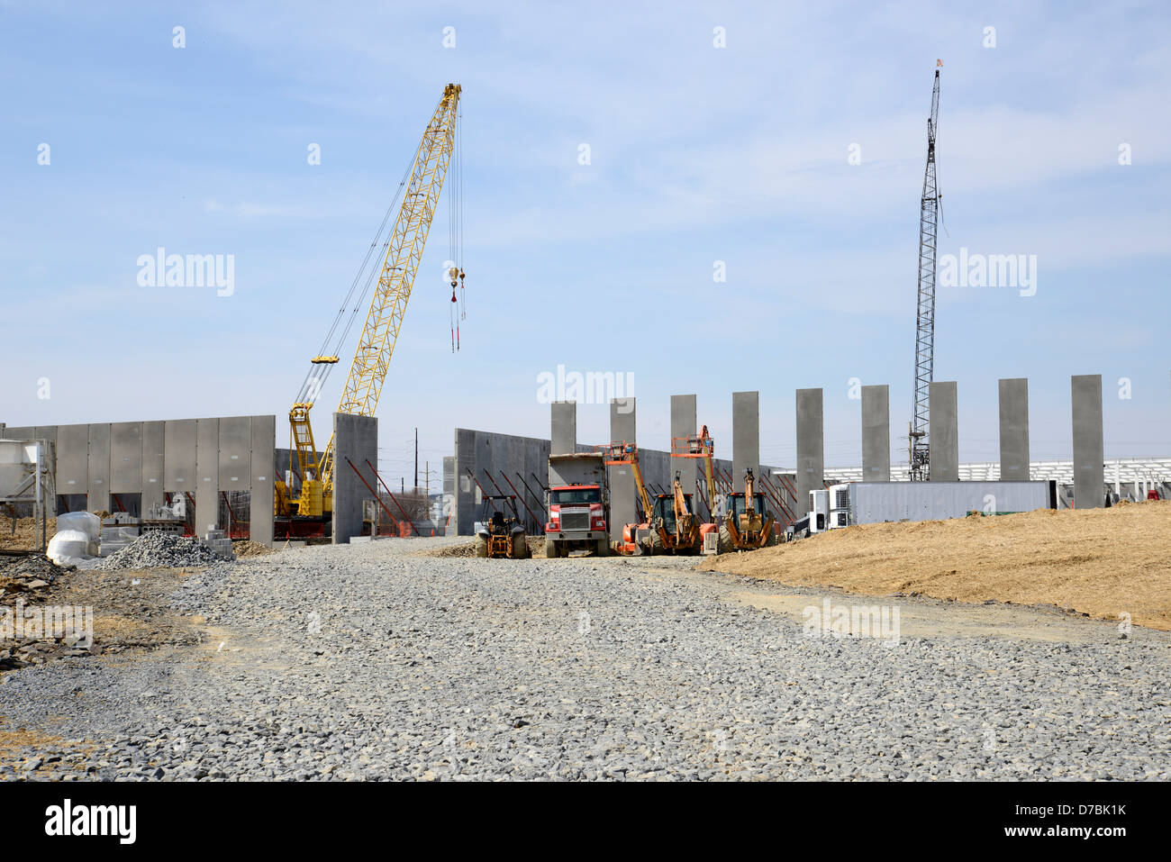 a large new warehouse under construction. There is excavation equipment on site Stock Photo Alamy