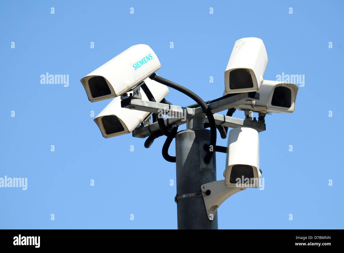 Several CCTV cameras bunched together with a blue sky background. Stock Photo