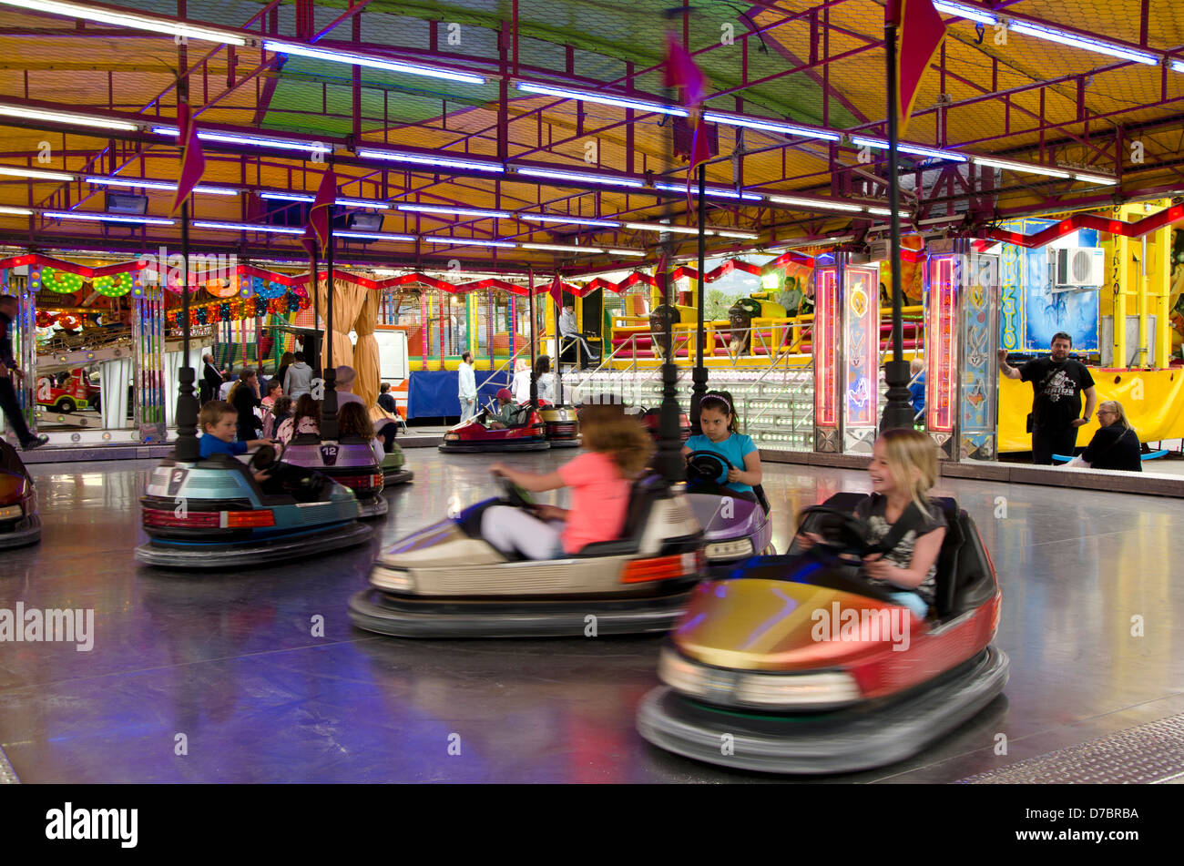 Children having fun in the bumper cars on a fair in a spanish village