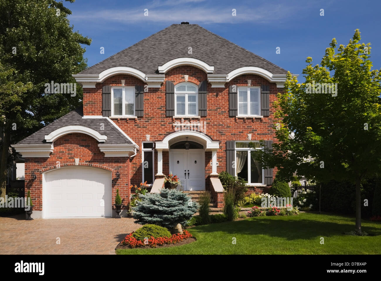 Red Brick Cottage Style Home With Landscaped Front Yard In Stock Photo