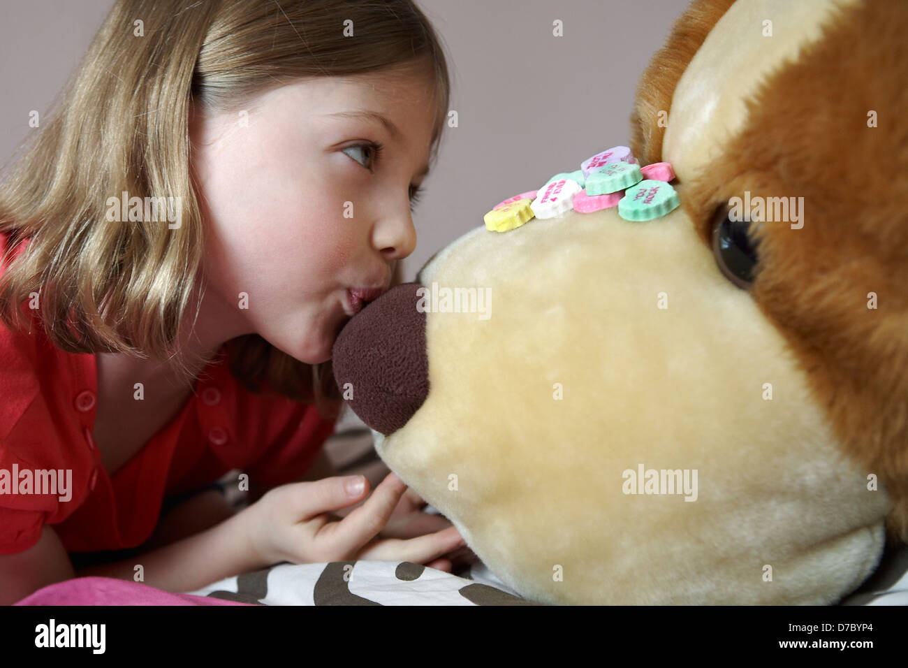 6 year old girl kissing stuffed animal Stock Photo
