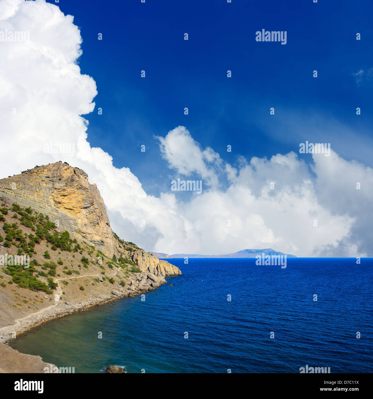Beautiful landscape with mountain and sea. White clouds in blue sky ...