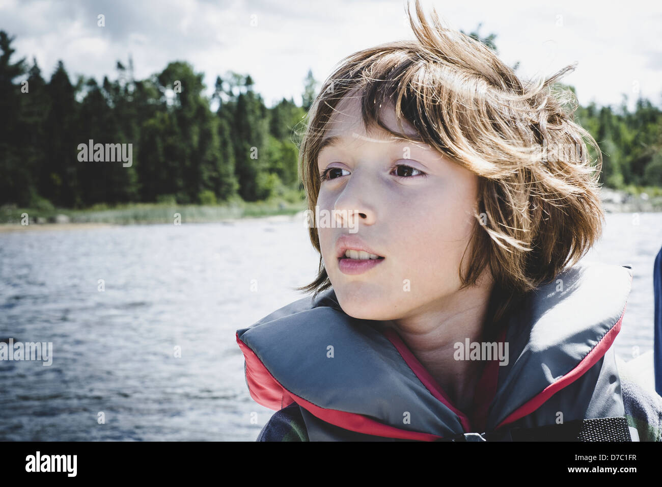 Boy On Lake Wearing Safety Vest And Looking In The Distance;Thetford