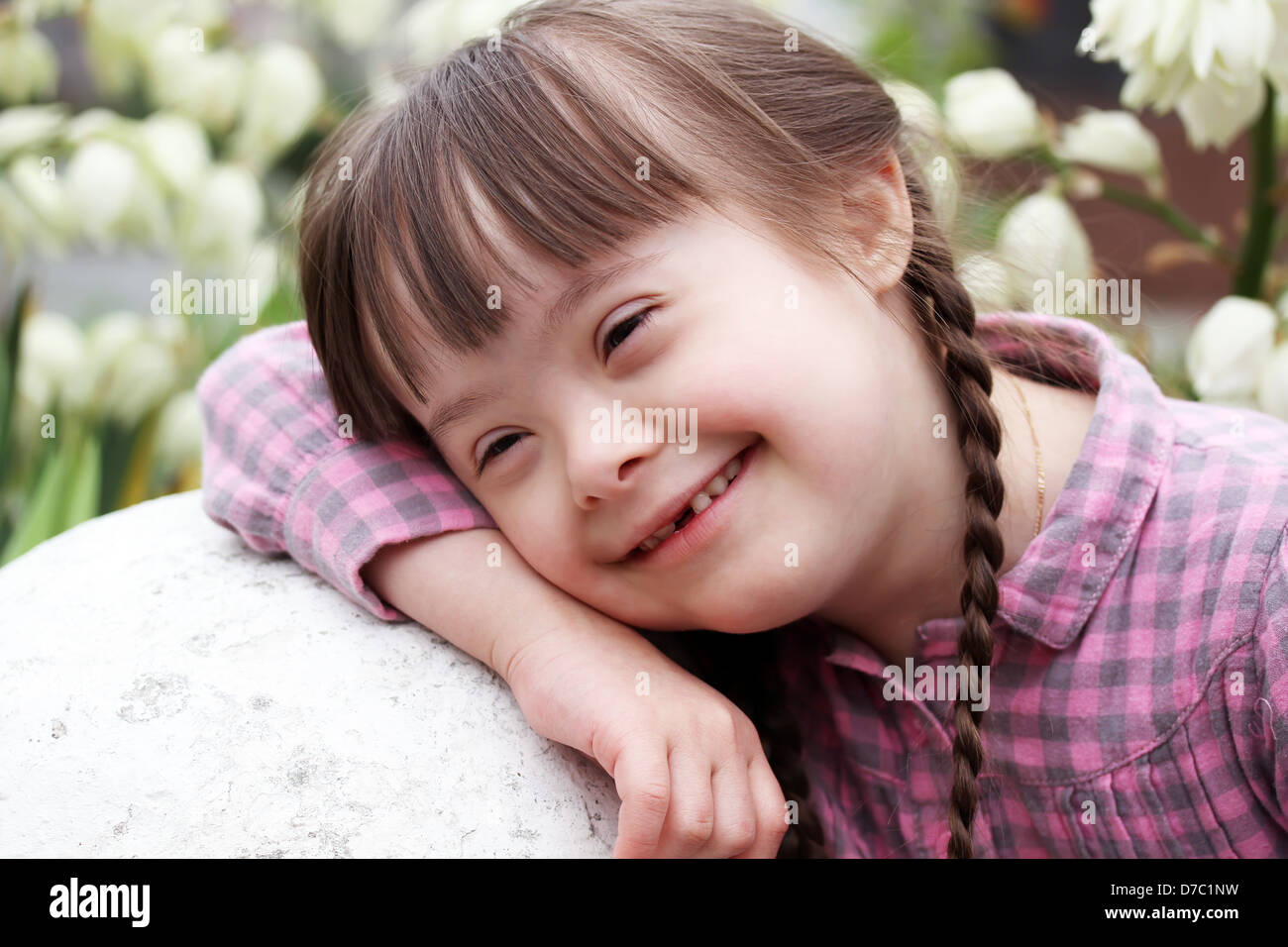 Portrait of smiling girl on flowers background Stock Photo - Alamy