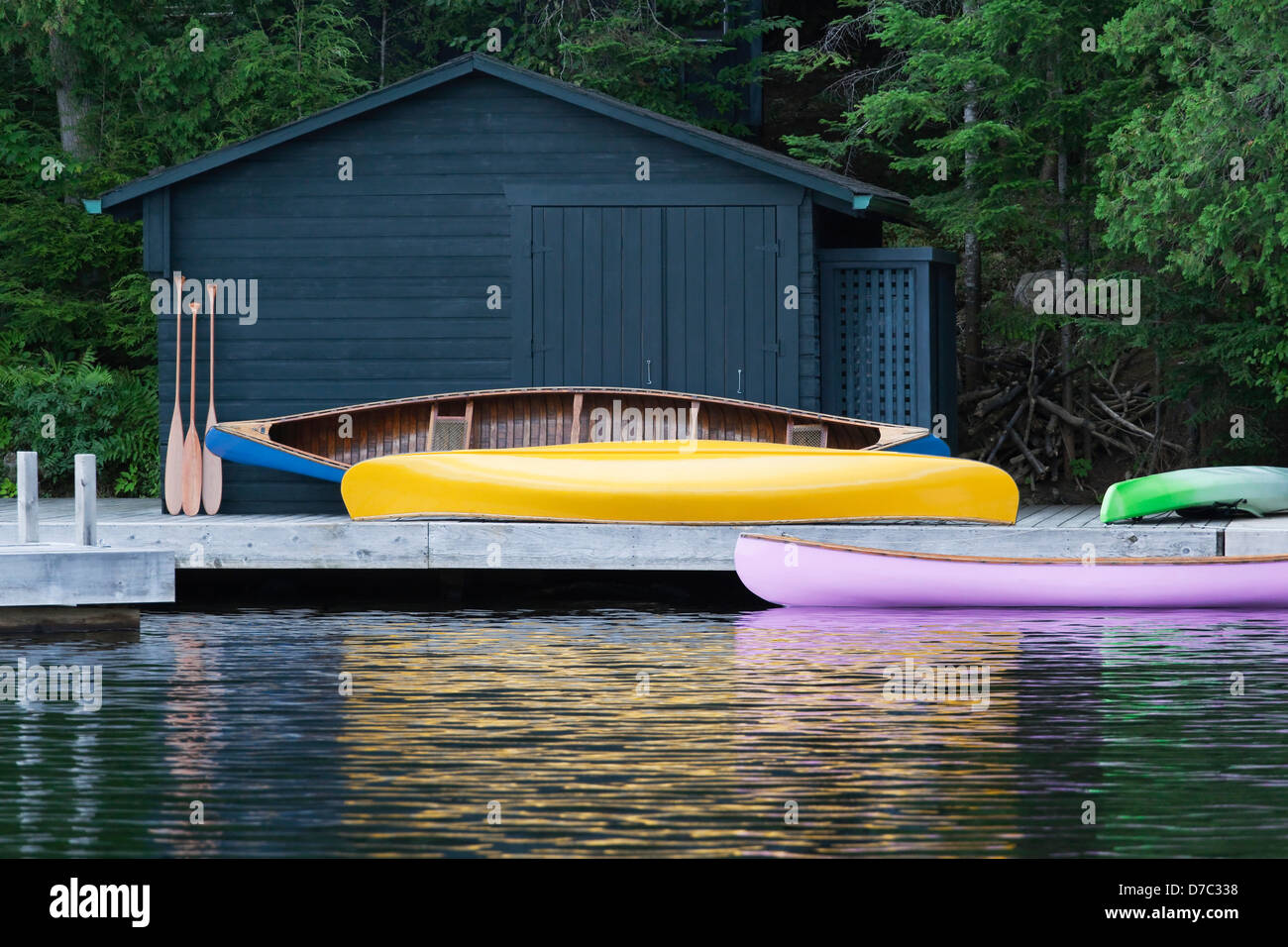 Colorful Canoes On A Cottage Dock And Reflected In The Water At Algonquin Park;Ontario Canada