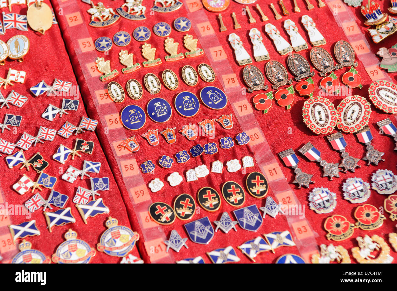 Loyalist/Unionist and masonic badges on sale at a market stall beside an Orange Order parade Stock Photo